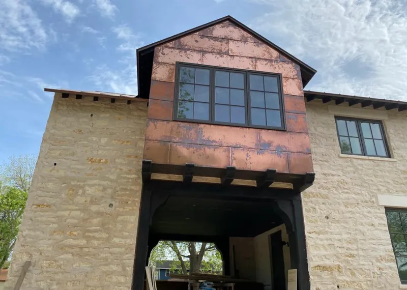 Copper metal panel facade on a stone building for Skylight Installation in Des Moines