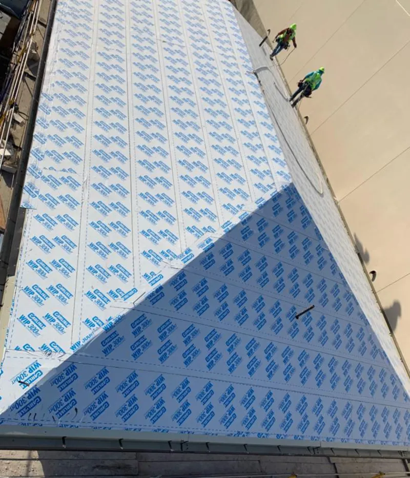 Professional roofers installing underlayment on a metal roof in Des Moines